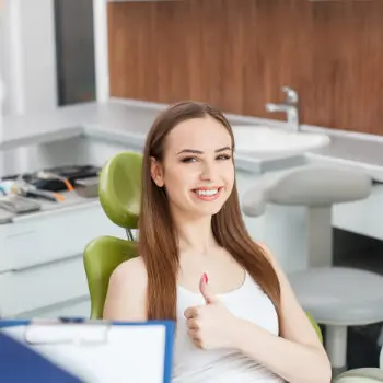 Pretty young woman sits satisfied in the dentist chair