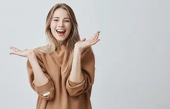 beautiful woman with blonde long hair looking at camera having excited and happy facial expression
